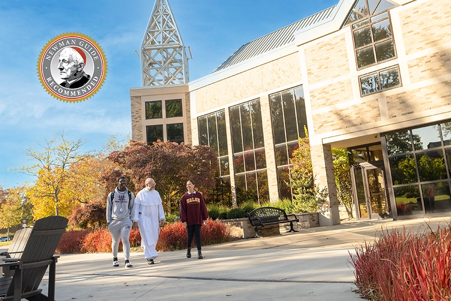 photo of the Walsh University Chaplain walking with two students on campus